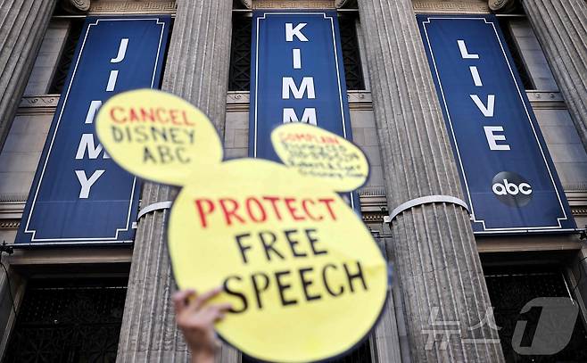 9월 22일(현지시간) 한 시민이 로스앤젤레스 할리우드 내 '지미 키멀 라이브' 제작 스튜디오 인근에서 열린 프로그램 중단 조치 항의 시위에서 '표현의 자유를 지켜라'라고 적힌 팻말을 들어 보이고 있다. 2025.09.22. ⓒ AFP=뉴스1 ⓒ News1 윤다정 기자