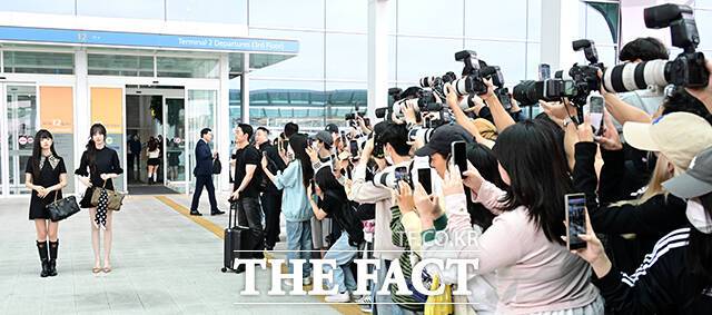 '아이브 떳다!' 아이브의 레이와 리즈를 보기 위해 모인 팬들이 사진 촬영을 하고 있다.