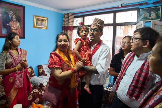 네팔에서 새로운 쿠마리로 선출된 아리아타라 샤카가 지난달 30일(현지시간) 카트만두에 있는 집에서 아버지에게 안겨 있다. AP=연합뉴스