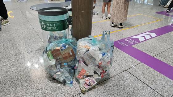 3일 인천공항 입국장 인근 쓰레기통 옆에 쓰레기가 가득찬 봉투가 치워지지 않고 놓여있는 모습. 김정재 기자