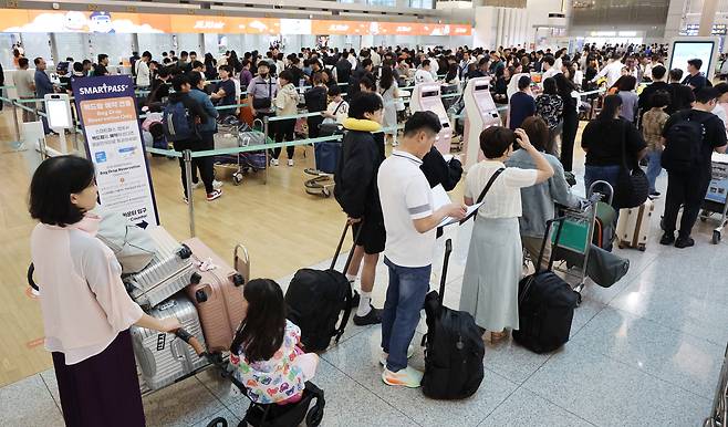 On the first day of the Chuseok holiday, Friday, travelers line up for check-in at Terminal 1 of Incheon International Airport. (Yonhap)
