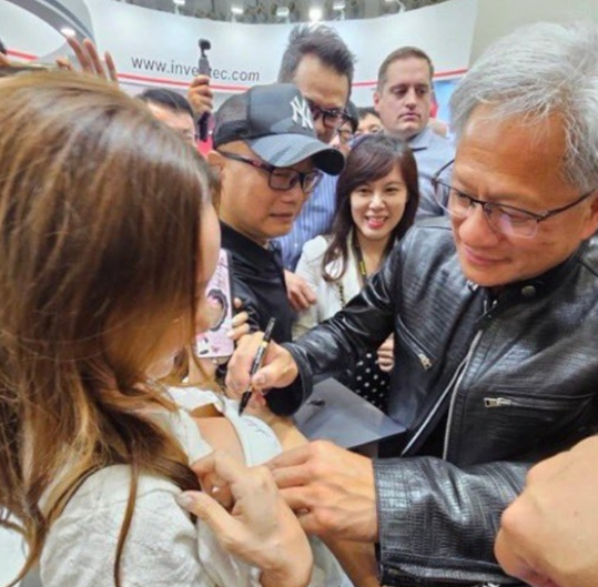 젠슨 황 엔비디아 창업자가 지난해 대만에서 열린 ‘컴퓨텍스 2024’ 행사에서 한 여성의 가슴에 사인하고 있다. 엑스 캡처