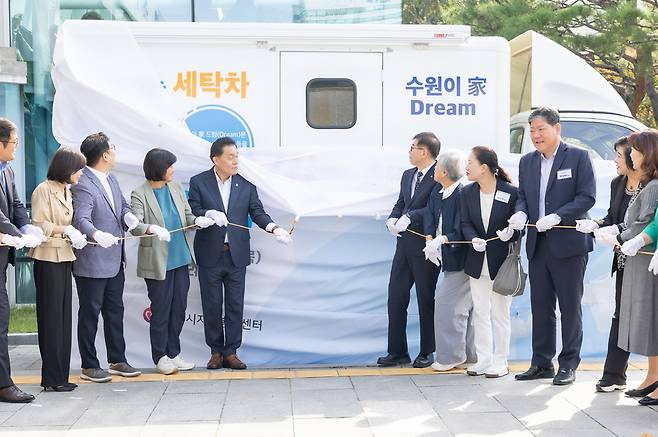 ▲ 이재준(중앙 왼쪽) 수원특례시장과 장정희(중앙 왼쪽에서 두 번째) 수원특례시의회 기획경제위원장, 창성수(중앙 오른쪽) MG새마을금고 지역나눔재단 사무국장을 비롯해 자원봉사단체장들이 2일 오전 수원시청 본관 앞에서 찾아가는 세탁차 제막식 기념촬영을 하고 있다. /사진제공=수원시