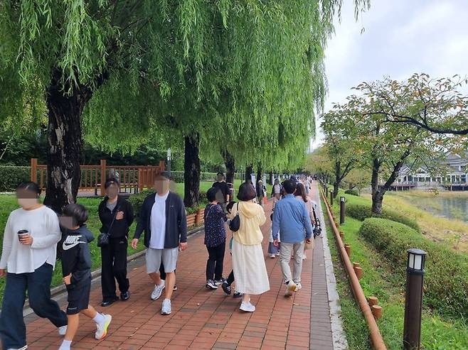 ▲ 추석연휴 이틀째인 4일, 흐린 날씨에도 불구하고 보문관광단지를 찾은 수많은 관광객들이 보문호수를 띠라 조성된 산책길을 걷고 있다. 황기환 기자