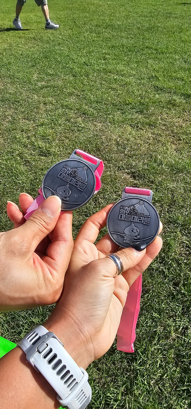 ▲ 9월 27일 경북 의성군 구봉공원에서 열린 제1회 의성마늘마라톤대회 완주 후 한 부부 러너가 함께 들어 올린 메달을 손에 쥔 모습이 관람객들의 눈길을 끌고 있다. 권미나씨 제공