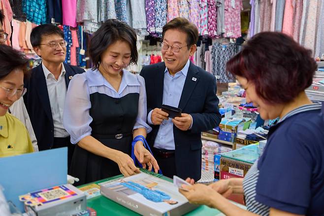 이재명 대통령과 김혜경 여사가 17일 서울 은평구 연서시장을 방문해 상품을 고르고 있다. (이재명 대통령 SNS)