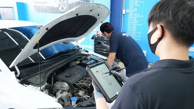 추석연휴 기간 장거리 주행을 준비하는 운전자들의 사전 차량 점검 필요성이 커지고 있다. 사진은 정비소 관계자들이 차량을 정비하는 모습. 사진=리본카 제공