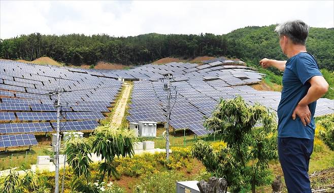 정부가 태양광 발전을 대폭 늘리면서 농촌에서 환경이 파괴되고 주민 생존이 위협당하고 있다는 지적이 나온다. 충남 공주시 사곡면의 한 주민이 피해를 끼치고 있는 태양광 패널을 가리키고 있다. 공주=김범준 기자