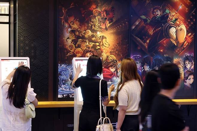 서울의 한 영화관을 찾은 관객들이 귀멸의 칼날 콜라보 카페 키오스크에서 주문을 하고 있다. 사진=뉴스1