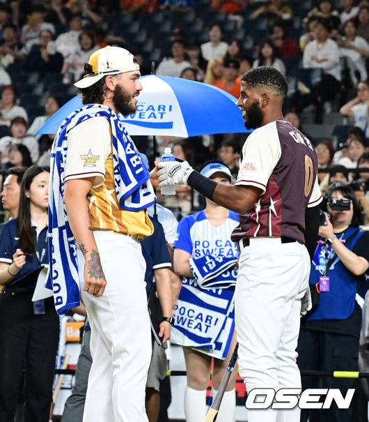 [OSEN=대전, 지형준 기자] 프로야구 삼성 라이온즈 르윈 디아즈가 홈런더비에서 우승을 차지했다.디아즈는 11일 대전 한화생명볼파크에서 열린 ‘2025 KBO 올스타전 컴투스프로야구 홈런더비’에서 예선 11홈런, 결선 8홈런을 기록하며 우승 트로피를 들어올렸다.&nbsp;한화 폰세가 홈런더비에 참가한 삼성 디아즈에 음료를 건네고있다. 2025.07.11 / jpnews@osen.co.kr