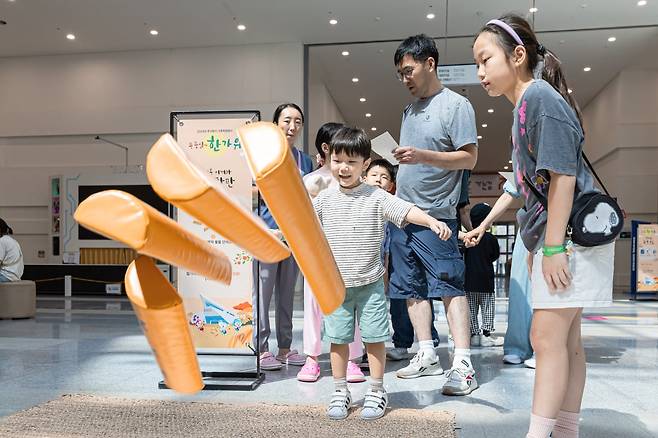 지난해 추석 연휴에 국립부산과학관을 방문한 관람객들이 윷놀이를 하며 과학 원리를 배우고 있다. /국립부산과학관