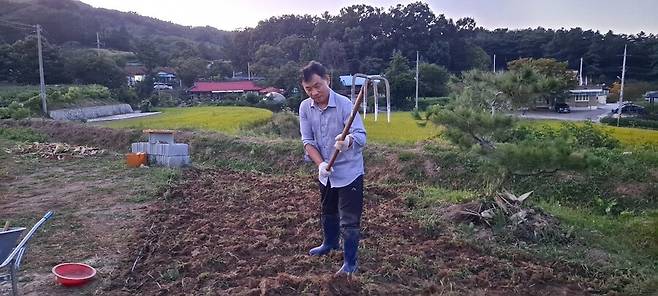 파종을 위해 밭을 쇠스랑으로 파고 있다.