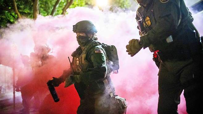 미국 오리건주 포틀랜드의 이민세관단속국(ICE) 시설 인근 시위대를 해산시키려고 최루탄을 투척하는 미국 연방요원들과 경찰