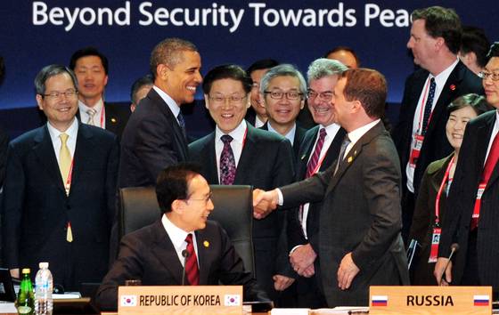2012년 3월 27일 서울 강남구 코엑스에서 열린 서울핵안보정상회의 제1세션에서 버락 오바마 미국 대통령과 드미트리 메드베데프 러시아 대통령이 의장인 이명박대통령을 사이에 두고 인사를 나누고 있다. 사진 공동취재단