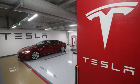 A Tesla is charged at a Supercharger in southern Seoul. [YONHAP]