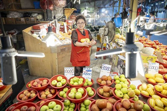 방신시장에서 수십 년간 과일가게를 하고 있는 ‘과일마켓’ 사장님이 명절 앞이라 장사가 잘된다며 환하게 웃고 있다.