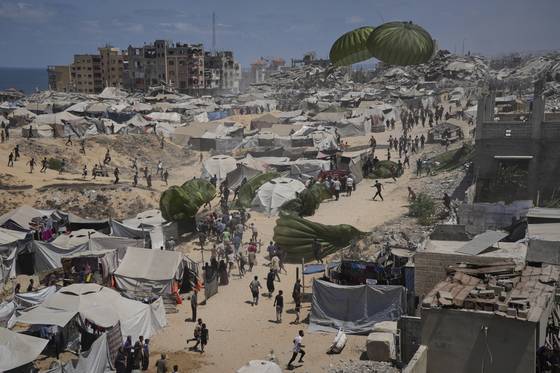 7일(현지시간) 가자시티에 구호 물품이 투하되자 주민들이 모여들고 있다. AP=연합뉴스