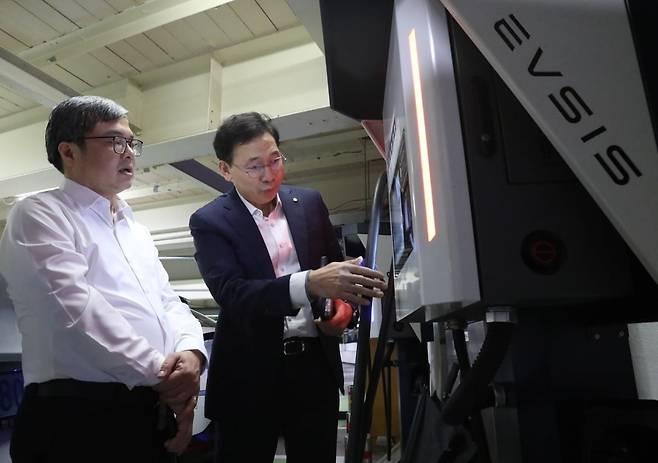 오영식 EVSIS 대표이사(오른쪽)가 쯔엉 비엣 중 하노이시 부시장에게 EVSIS 전기차 중전기를 설명하고 있는 모습. 롯데이노베이트 제공