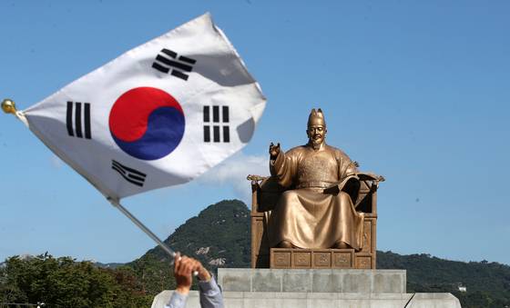 A citizen waves the Taegeukgi Korean flag on Hangul Day on Oct. 9, 2024, in front of the King Sejong statue in Gwanghwamun, central Seoul. [NEWS1]
