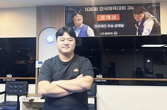 정예성이 자신의 ‘전국체전 금메달’ 기념 플래카드가 걸려있는 시흥 배곧 니즈당구클럽에서 포즈를 취하고 있다. (사진=니즈당구클럽 제공)