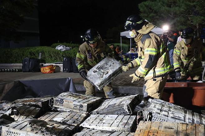 [대전=뉴시스] 강종민 기자 = 화재가 발생한 대전 유성구 국가정보자원관리원에서 27일 소방대원이 불에 탄 리튬이온 배터리를 소화수조로 옮기고 있다. (사진=총리실sns) 2025.09.27. photo@newsis.com *재판매 및 DB 금지