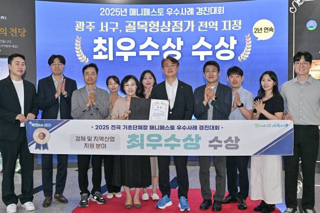 김이강 광주시 서구청장(오른쪽 다섯번째)이 지난 7월 28일 전국 기초단체장 매니페스토 우수사례 경진대회에서 골목형상점가 전역 지정 정책으로 경제 및 지역산업 지원 분야 최우수상을 수상하고 직원들과 함께 기념촬영을 하고 있다. 사진 제공=광주 서구