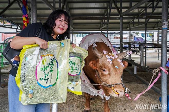 정민경(24)씨가 7일 경남 의령군 의령민속경기장에서 열린 ‘추석 소힘겨루기 대회’에서 초롱이에게 먹일 티모시풀을 들어보이고 있다.