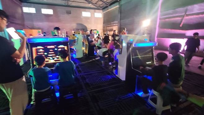 ▲ 2025 구미산단페스티벌에 관람온 형제 와 아버지와 아들이 전자오락기 게임을 즐기고 있다. 이봉한기자