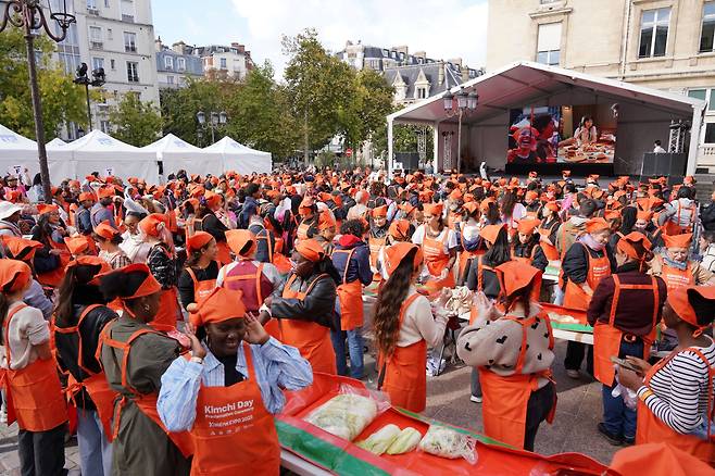 지난 4일(현지 시각) 프랑스 파리15구 청사 대광장에서 열린 '2025 KOREAN EXPO - 김치의 날 제정 선포식'에서 파리 시민들과 관광객들이 김장 버무림 행사에 참여하고 있다. /대상
