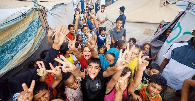 AFP 연합뉴스팔레스타인 난민촌에 찾아온 희망  이스라엘과 하마스가 평화 구상 1단계에 합의한 소식이 전해진 9일, 가자지구 중부 누세이라트 강제 이주자 캠프의 어린이들이 모여 손으로 ‘브이(V)’ 자를 만들어 보이고 있다.