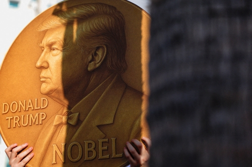 노벨상 메달에 트럼프 얼굴 합성한 피켓 든 이스라엘 시위자. [로이터=연합뉴스]