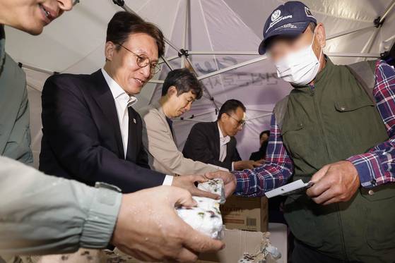 김민석 국무총리가 10일 서울 구로구 남구로역 인근 인력시장을 방문해 건설 일용근로자들에게 간식과 팔토시 등 격려물품을 전달하고 있다. 뉴스1