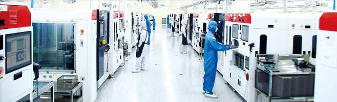 < 韓반도체 기업, 베트남 진출 러시 > 한국 반도체 회사들이 우수 인력을 쉽게 확보할 수 있는 베트남에 잇달아 진출하고 있다. 베트남 박닌성 산업단지에 있는 하나마이크론 공장에서 직원들이 반도체 조립 작업을 하고 있다.  /하나마이크론 제공