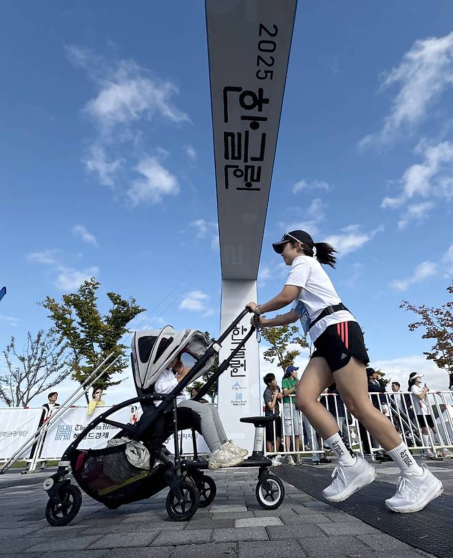 A runner with a child in a stroller takes part in the 2025 Hangeul Run at Sejong Central Park on Thursday. (Park Hae-mook/The Korea Herald)