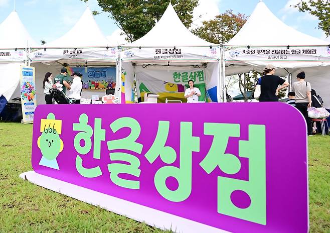 Visitors explore booths showcasing Hangeul-themed products at the Hangeul Goods Fair held at Sejong Lake Park on Thursday. (Lee Sang-sub/The Korea Herald)