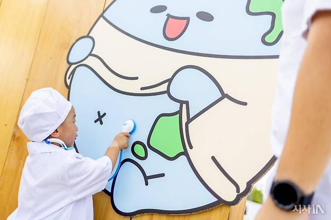 전세계 어린이(22개월)가 지구 그림에 청진기를 대고 있다. ⓒ시사IN 박미소