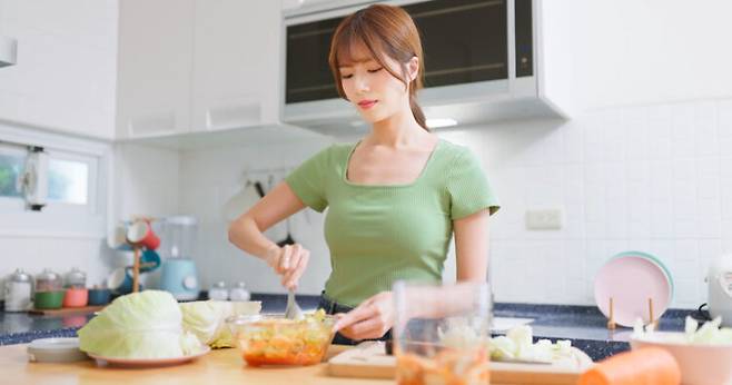 주방에서 식사 준비를 하고 있는 여성. 담배를 피우지 않는 여성이 폐암에 걸리는 사례가 매우 많다. 비흡연자의 폐암 원인으로는 라돈, 대기오염, 주방 조리 시 연기, 유전적 요인, 간접흡연, 석면 등 직업적 노출 등을 꼽을 수 있다. 사진=게티이미지뱅크