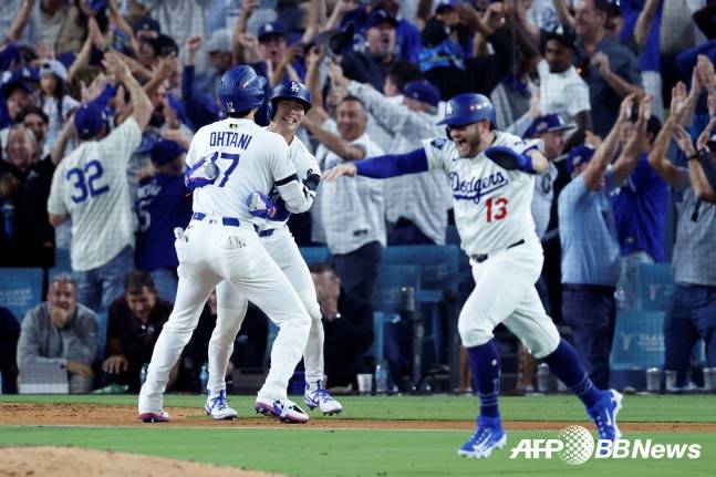 김혜성이 10일(한국시간) 필라델피아 필리스와 2025 메이저리그 포스트시즌 NLDS 4차전 연장 11회말 2사 만루서 결승득점을 기록한 뒤 오타니 쇼헤이와 안고 기뻐하고 있다. /AFPBBNews=뉴스1