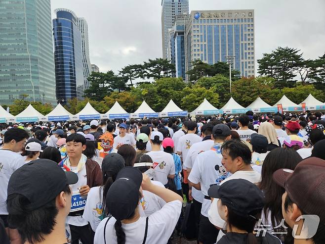 11일 서울 여의도공원 일대에서 '디즈니런 서울 2025'(Disney Run 2025)이 개최됐다. 러닝 후 음료 및 메달 수령을 기다리는 사람들 모습.ⓒ 뉴스1/김진희 기자.