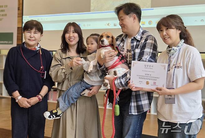 강소영 서울디지털대학교 교수(맨 왼쪽)와 김세현 비글구조네트워크 대표(맨 오른쪽)가 제1회 입양제를 통해 입양 간 비글 '동백이' 가족에게 입양증서를 전달한 후 기념 사진을 찍고 있다. ⓒ 뉴스1 한송아 기자
