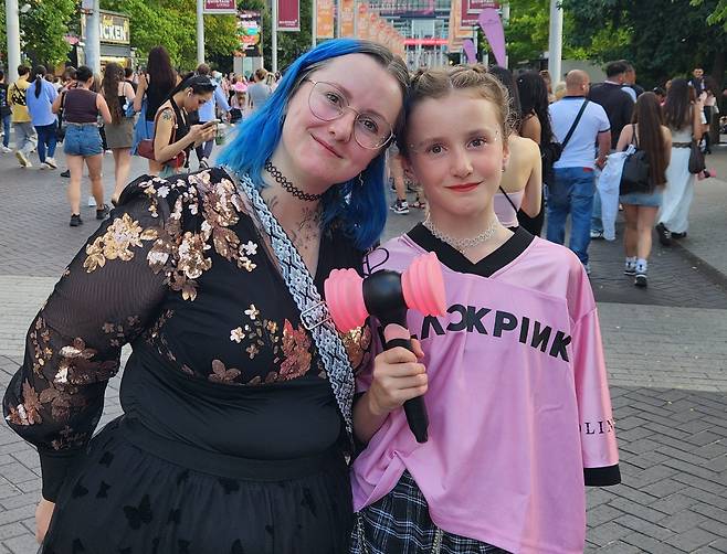 걸그룹 블랙핑크의 공연 첫날인 지난 8월 15일 오후 영국 런던 웸블리 스타디움 앞에서 팬들이 인터뷰 후 포즈를 취하고 있다.영국 팬이 블랙핑크 응원봉을 들고 있는 모습./연합뉴스