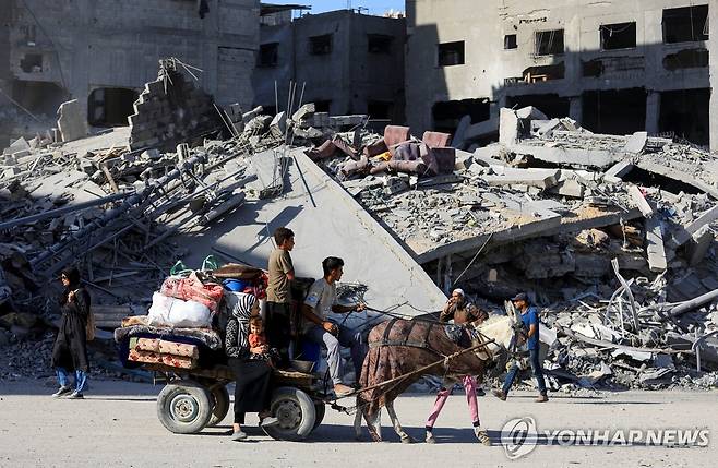 11일(현지시간) 폐허가 된 가자시티로 들어서는 팔레스타인인들 [로이터 연합뉴스 재판매 및 DB 금지]