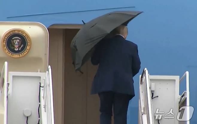 도널드 트럼프 미국 대통령이 12일(현지시간) 이스라엘로 출발하는 에어포스원에 탑승하기 전 우산을 접지 못하는 모습이 포착됐다. 2025.10.13./뉴스1