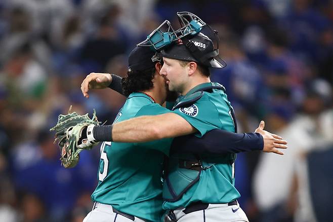 시애틀 마무리 안드레스 뮤노즈가 9회 2점차 승리를 지킨 뒤 포수 칼 롤리와 포옹하고 있다. AFP연합뉴스