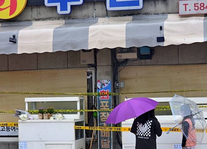 13일 오전 경기 가평군 청평면 청평리의 한 횟집 앞을 지나던 동네 학생들이 발걸음을 멈추고 현장을 살펴보고 있다. 송상호 기자