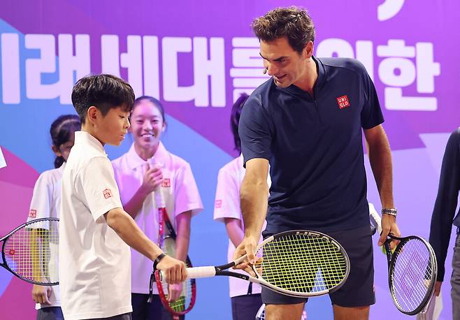 로저 페더러가 13일 서울 중구 신라호텔에서 열린 유니클로의 미래 세대 육성 캠페인 ‘로저 페더러와 함께하는 세계 여행\' 행사에서 국내 유소년 선수들을 대상으로 특별 코칭을 진행하고 있다. 연합뉴스