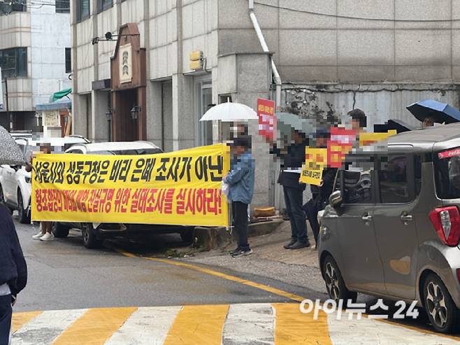 13일 성수1지구 조합 사무실 앞에서 일부 조합원들이 피켓 시위를 벌이고 있다. [사진=독자제공]