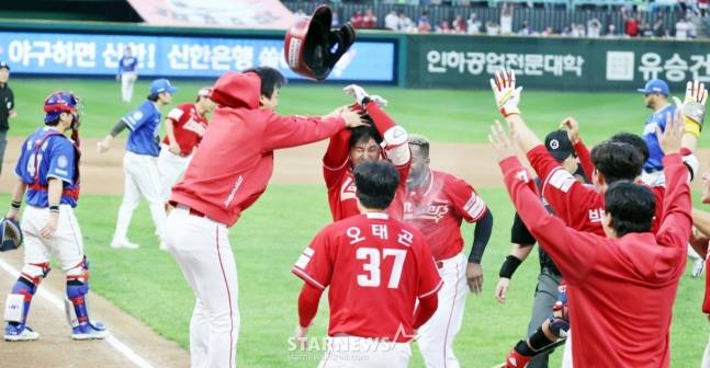 SSG 김성욱(가운데)이 11일 삼성과 준PO 2차전에서 끝내기 홈런을 날린 뒤 동료들의 뜨거운 환영을 받고 있다. /사진=강영조 선임기자