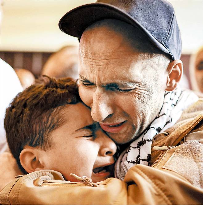 모두 가족의 품으로  이스라엘과 팔레스타인 무장 단체 하마스가 인질과 수감자를 교환한 13일, 자유를 얻은 양측 사람들이 가족과 재회하고 있다. 2023년 10월 가자지구에서 억류됐다가 석방된 이스라엘인 옴리 미란(위쪽 사진 오른쪽 인물), 이스라엘이 점령한 서안지구에서 붙잡힌 팔레스타인 남성(아래쪽 사진 오른쪽 인물)이 각각 가족의 품에 안기는 모습./AFP 연합뉴스