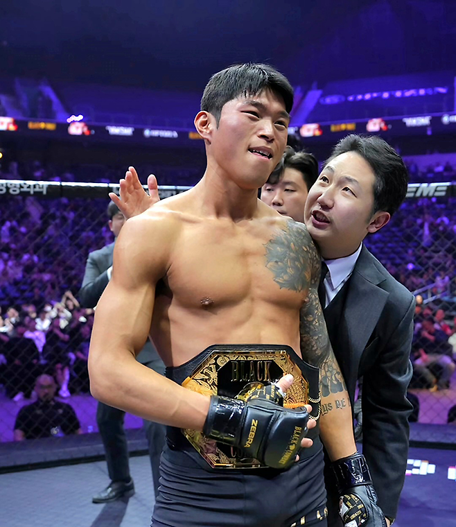 ‘야차’ 최준서가 2025년 5월 인천광역시 영종국제도시 인스파이어 아레나에서 초대 블랙컴뱃 웰터급 챔피언으로 등극한 후 감회에 젖어 있다. 오른쪽은 블랙컴뱃 박평화 대표. 사진=이데아 파라곤